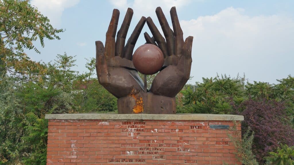 billede af hænder fra memento park med kommunistiske symboler og helteskikkelser budapest